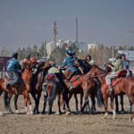 Energetic scene of a traditional Buzkashi game with men on horseback in Kabul, Afghanistan.