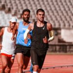 Three determined athletes compete in a track and field race, showcasing energy and focus.