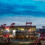 View of Nissan Stadium in Nashville, Tennessee, under a dramatic cloudy sky at dusk.