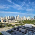 A stunning view of the Miami skyline with clear skies and bustling city life.