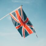 Union Jack flap in the breeze against a clear blue sky, symbolizing British pride.