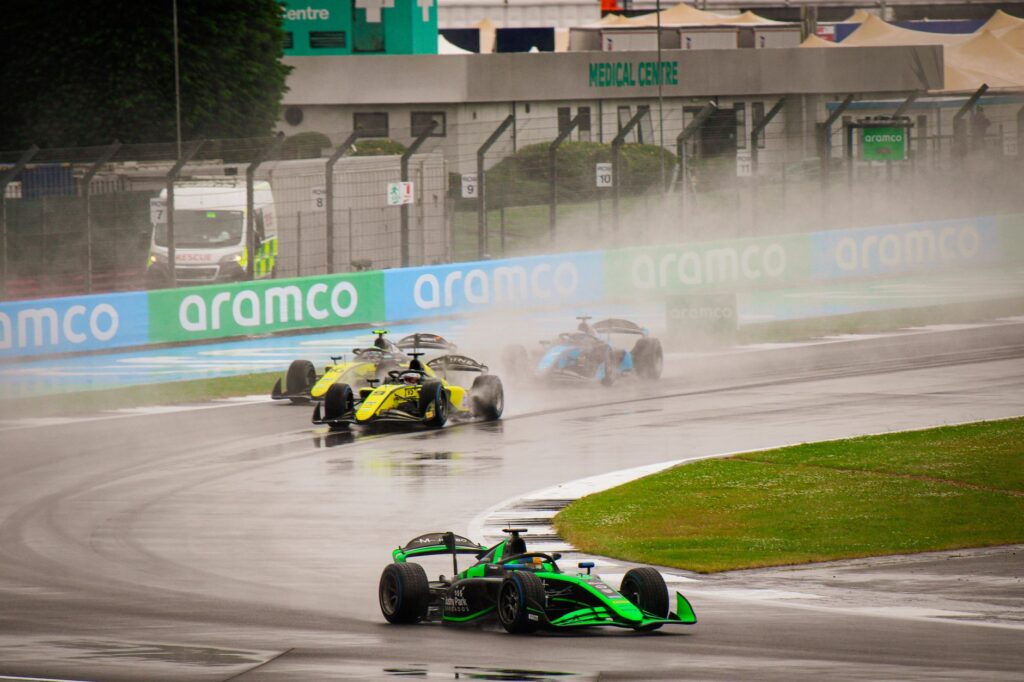 Exciting Formula 1 race on a wet track showcasing high-speed dynamics.