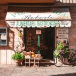 A quaint Italian grocery store with fresh produce and a vintage bicycle outside, offering local delicacies.