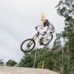 Professional mountain biker performing an aerial stunt in Maydena, Tasmania.