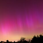 Vibrant aurora borealis illuminates the night sky over Geneva, creating a stunning natural display.