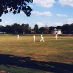 A cricket match being played on a sunny day in Norwich, showcasing players in action.