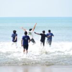Group of friends playing and enjoying a sunny day at Cox's Bazar beach, Bangladesh.