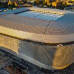Aerial shot of Santiago Bernabéu Stadium in Madrid during sunset showcasing its modern architecture.