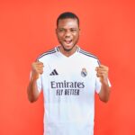 Energetic soccer fan in a team jersey cheering against a vibrant red background.