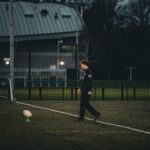 Rugby player sets up for a kick on an empty field in England.