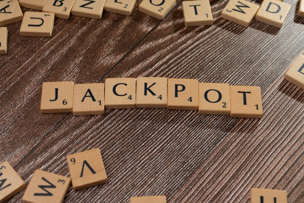 Wooden letter tiles spelling 'JACKPOT' on a textured wooden surface, representing winning or success.