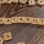 Wooden letter tiles spelling 'JACKPOT' on a textured wooden surface, representing winning or success.