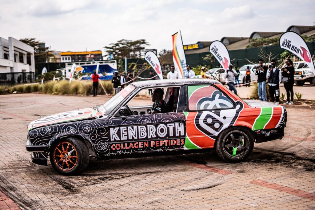 Colorful custom car wrapped with Kenbroth branding at an outdoor automotive event.