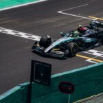 High-speed Formula 1 car crossing the finish line on a race track during the day.
