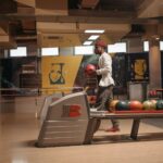 A man getting ready to bowl inside a stylish, modern bowling alley with colorful balls.