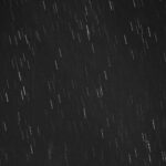 Black and white photo of star trails created with long exposure at night.