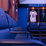 Professional football locker room in Paris with player jerseys displayed.