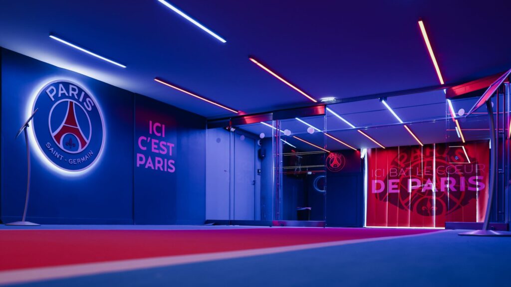 Spacious PSG entrance hallway in Paris with striking neon lighting and club branding.
