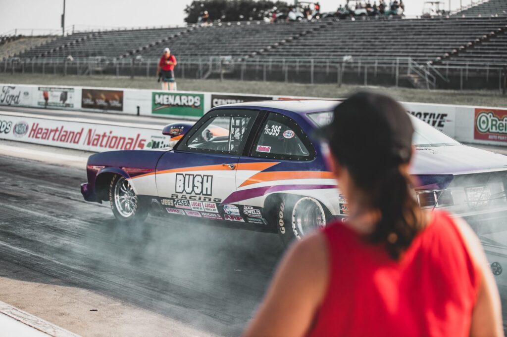 A thrilling drag race event at Heartland Nationals in Topeka, showcasing modified race cars and dynamic competition.