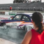 A thrilling drag race event at Heartland Nationals in Topeka, showcasing modified race cars and dynamic competition.