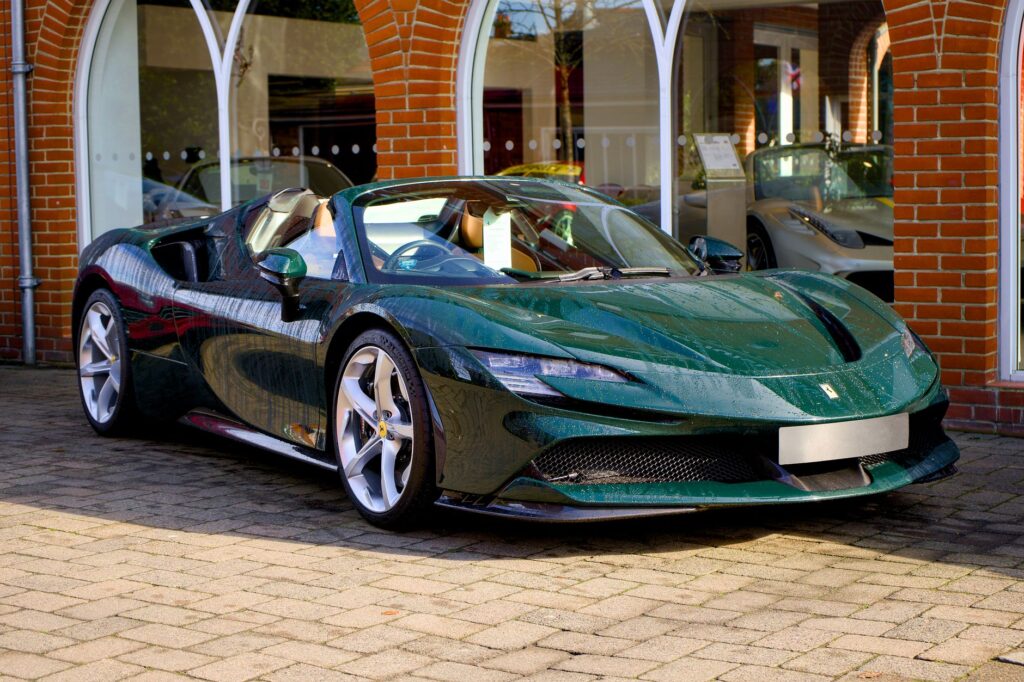 Elegant green Ferrari sports car with alloy wheels displayed outdoors, showcasing speed and Italian design.