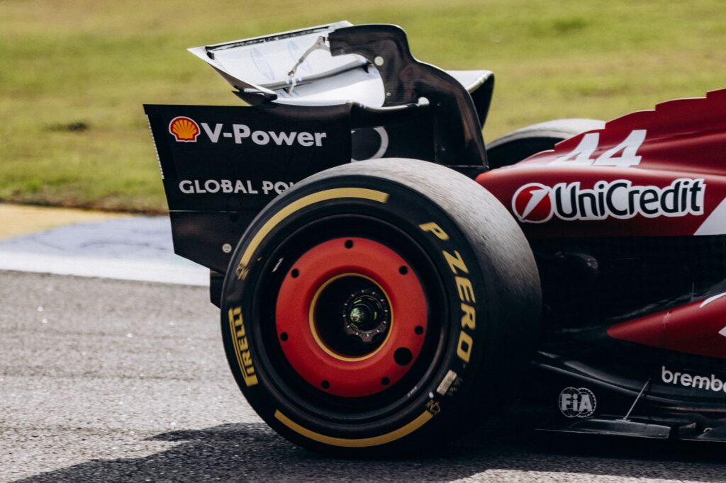 Close-up of a Ferrari Formula 1 car's rear wing and tire on the Interlagos track in São Paulo, Brazil.