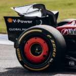 Close-up of a Ferrari Formula 1 car's rear wing and tire on the Interlagos track in São Paulo, Brazil.