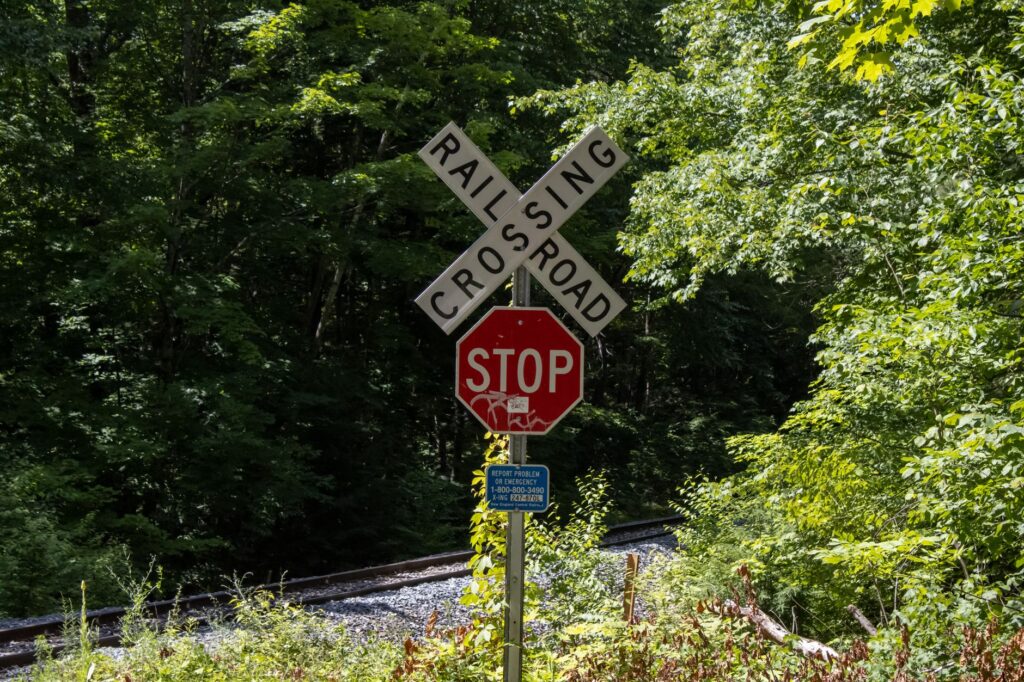Close-up of a railroad crossing and stop sign in a wooded area in Sunderland, Massachusetts.