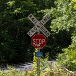 Close-up of a railroad crossing and stop sign in a wooded area in Sunderland, Massachusetts.