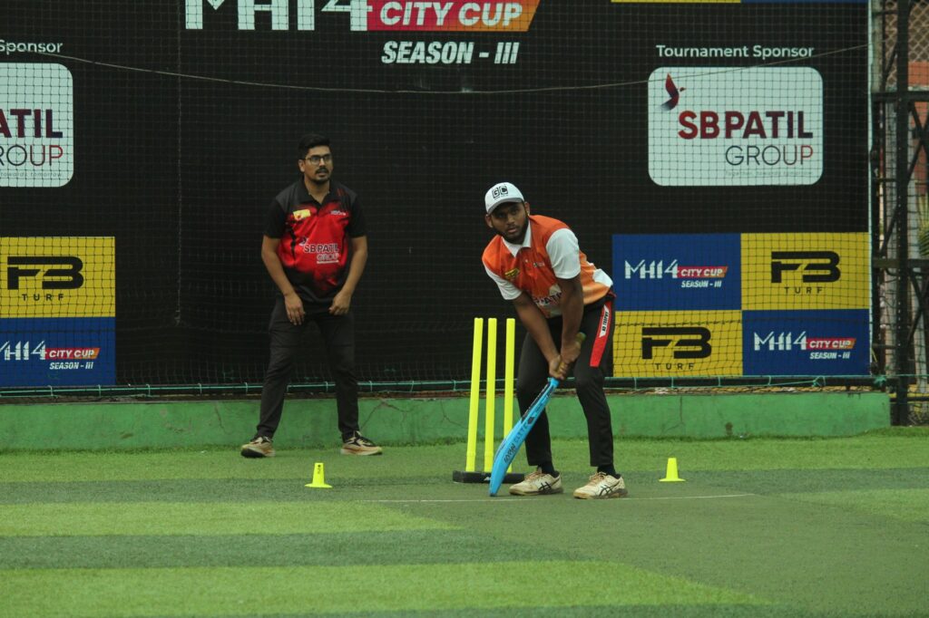 Two cricket players on a turf field during the MH14 City Cup Season III match.