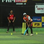 Two cricket players on a turf field during the MH14 City Cup Season III match.