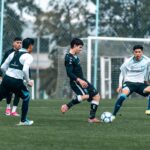 Soccer players engage in a competitive training session on a grassy field outdoors.