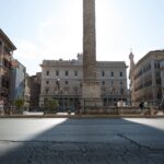 A vibrant daytime scene of an ancient column in a Rome city square with tourists and historic architecture.