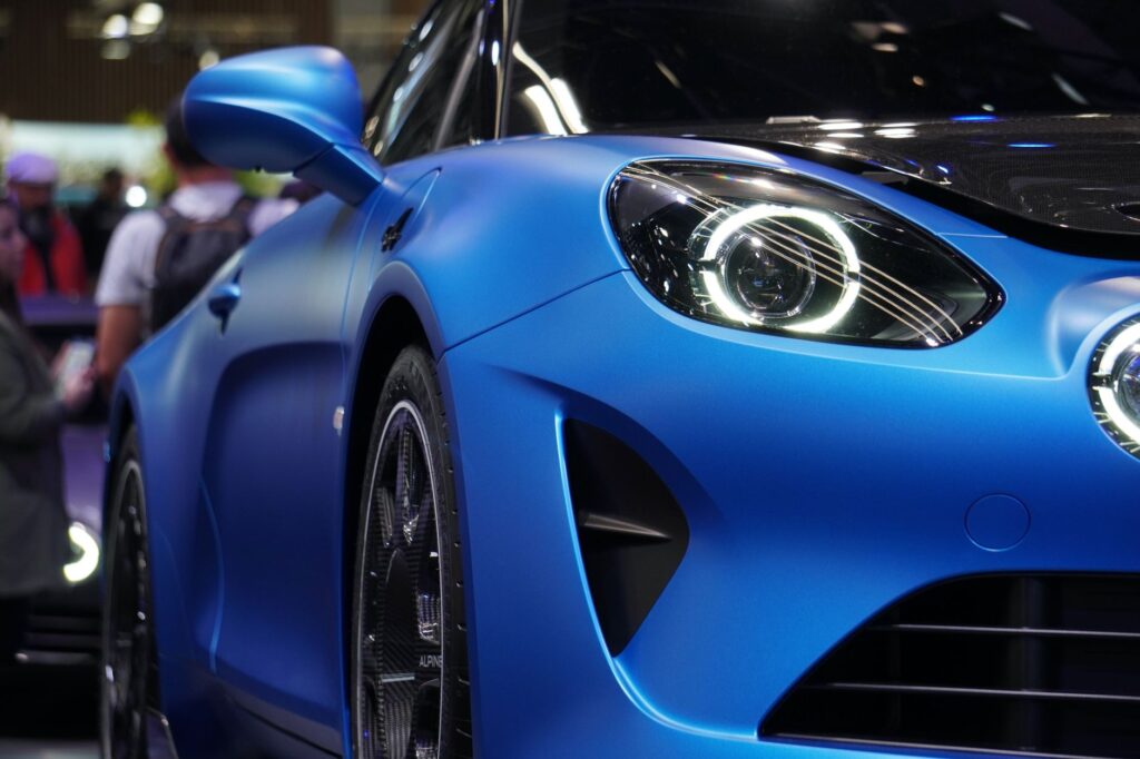 Detailed view of a blue Alpine A110 sports car showcased at a car exhibition.