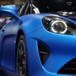 Detailed view of a blue Alpine A110 sports car showcased at a car exhibition.