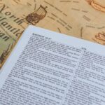 Open Bible with text from Matthew 26:47 on vintage map of North Atlantic Ocean.
