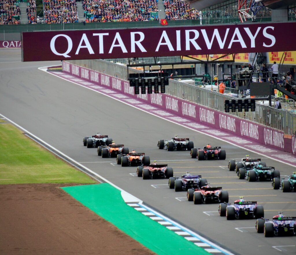 High-speed Formula 1 cars line up on the Silverstone Circuit, ready for an adrenaline-pumping race.