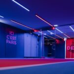 Spacious PSG entrance hallway in Paris with striking neon lighting and club branding.