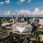 Stunning aerial view of Atlanta skyline featuring the iconic Mercedes-Benz Stadium on a clear day.