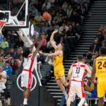 Dramatic moment in a basketball game with players and an engaged crowd.