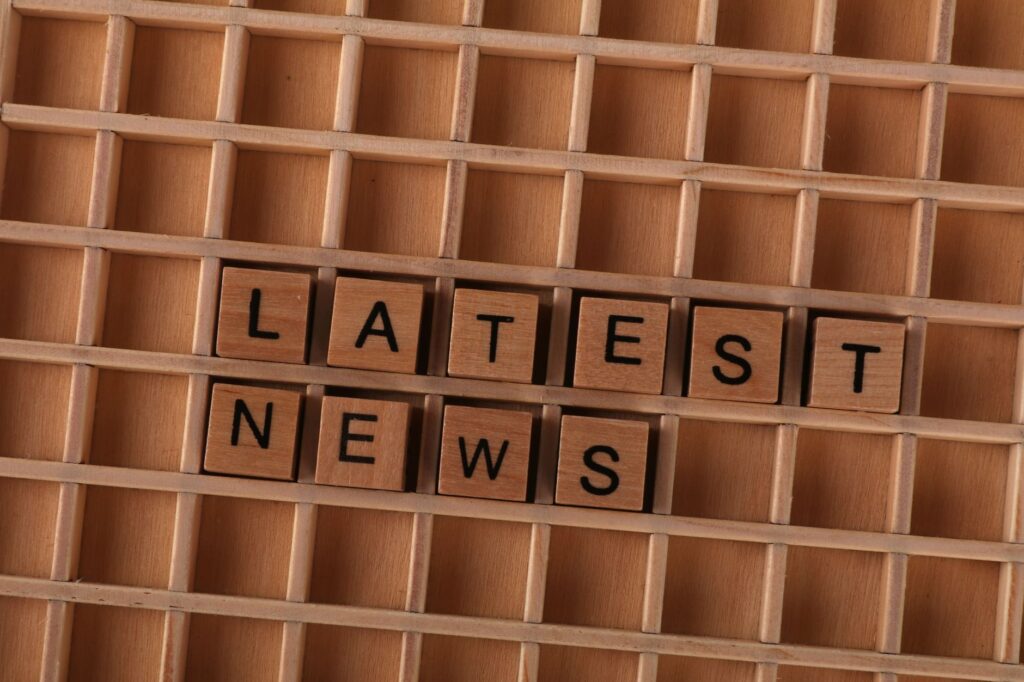 Wooden letter blocks spelling Latest News on a grid background, ideal for media themes.