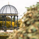 Charming garden gazebo with ornate wrought iron structure surrounded by lush greenery in Papplewick, England.
