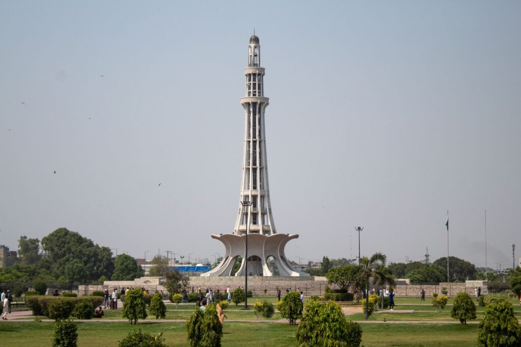 Stunning daytime capture of Minar-e-Pakistan surrounded by lush greenery in Lahore.