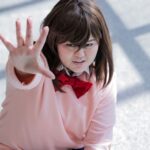 Young adult in anime-inspired cosplay, energetically posing indoors.
