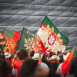 Crowd of Portuguese fans waving flags at Allianz Arena in Munich during a football event.