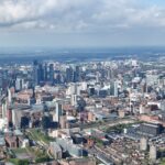 Stunning aerial photograph of Manchester's urban skyline showcasing modern architecture under scattered clouds.