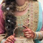 Close-up of an Indian bride showcasing traditional clothing and henna with ornate jewellery.