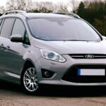 Silver Ford C-Max SUV parked on a road in the UK. Ideal for automotive themes.