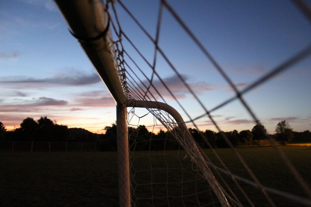 A serene sunset view highlighting a soccer goal net in a Louisville park, perfect for sports enthusiasts.