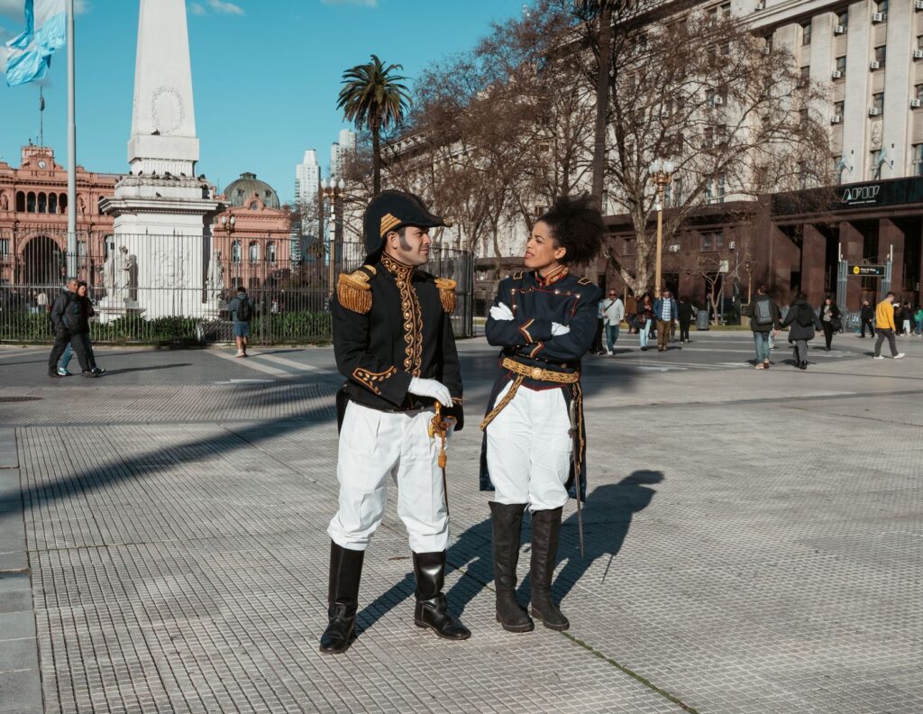 Historical reenactors in uniform at Plaza de Mayo, Buenos Aires, Argentina, with Casa Rosada view.